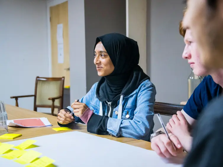 Two young people talking and participating in a workshop.