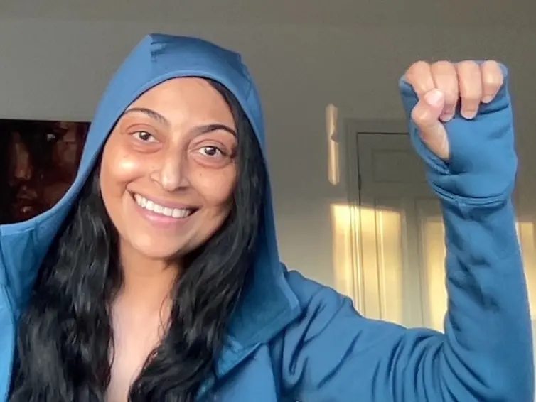 A person smiling with fist up celebrating a win.