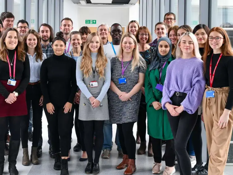 Large group of people smiling looking at camera.
